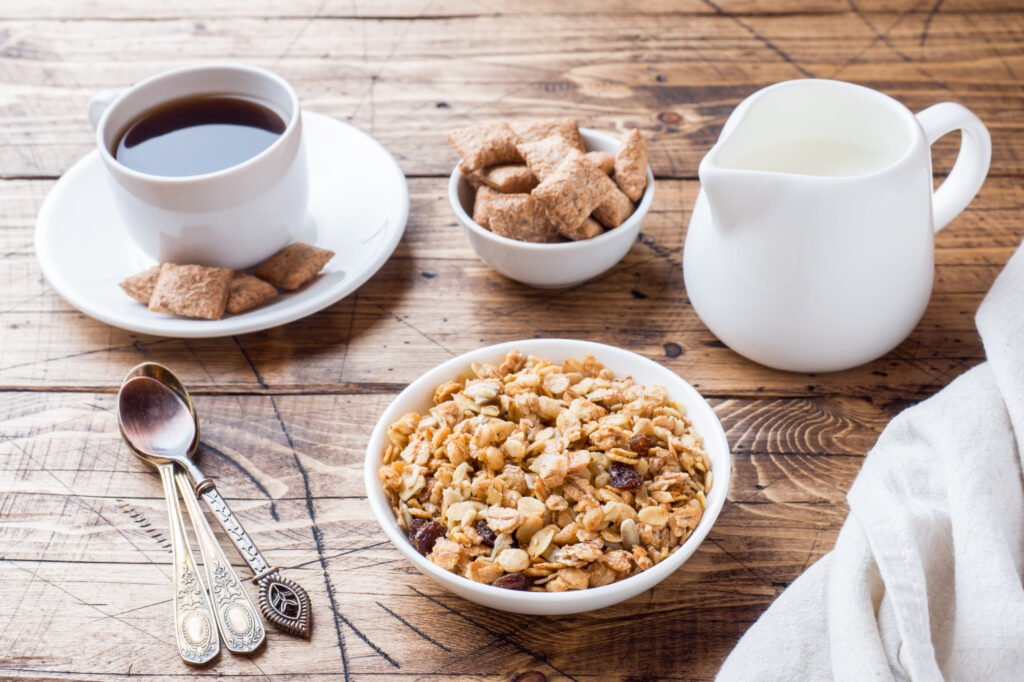 Dining table laid out with cereal bowls, coffee, and milk